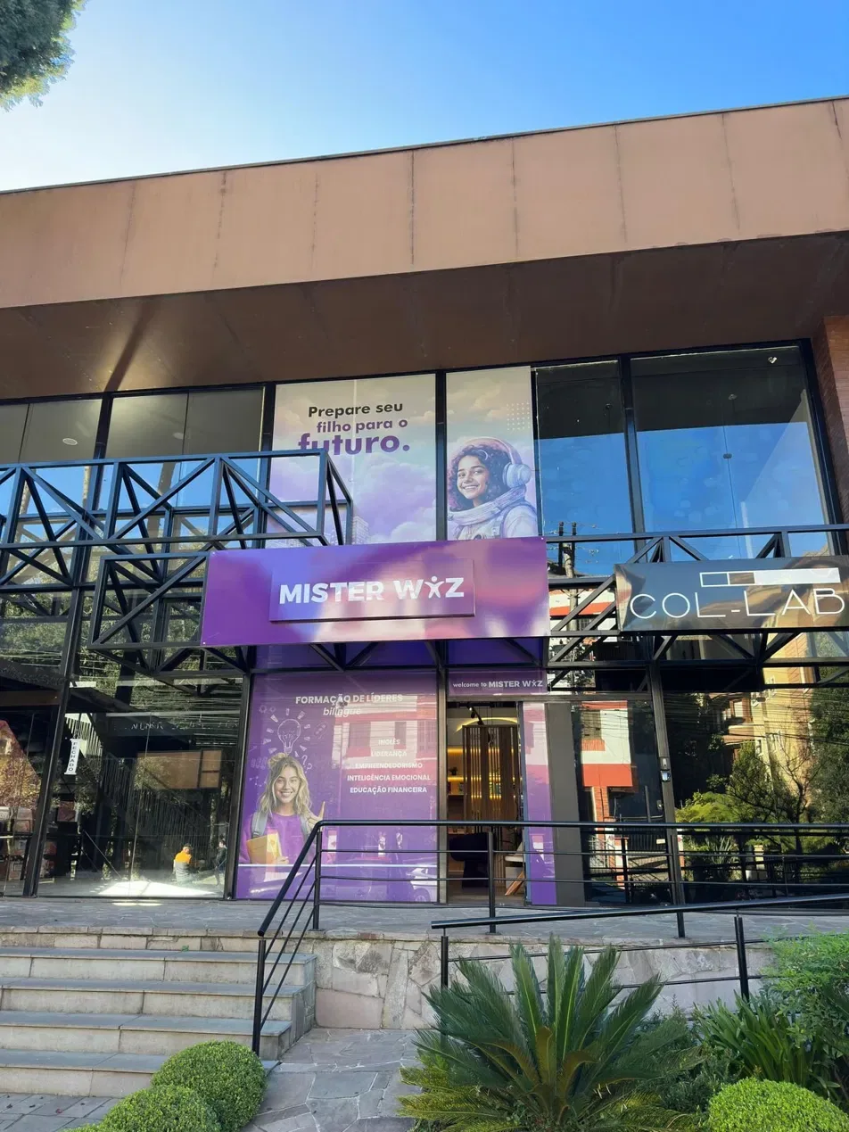 Vista externa da escola com o letreiro Mister Wiz e o caminho de entrada.